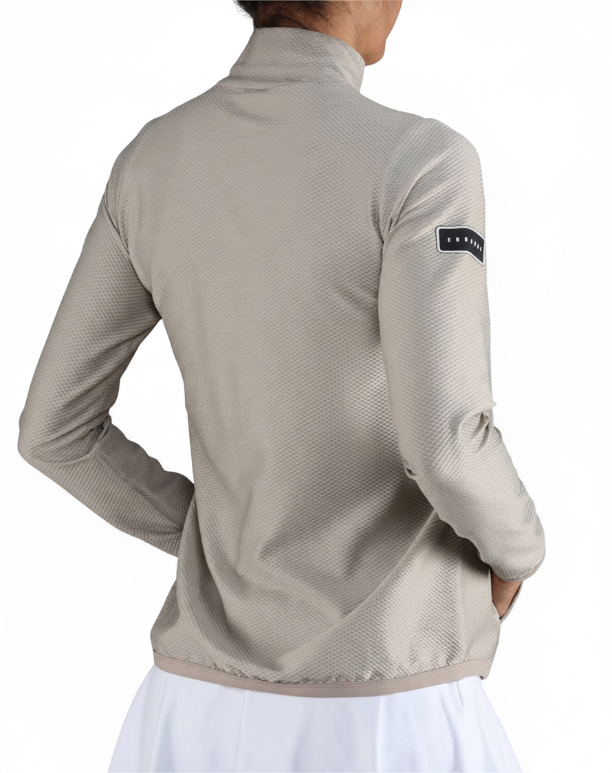 Chaqueta deportiva Endless MX Lithe de color beige con cuello alto, cremallera y tejido elástico transpirable.